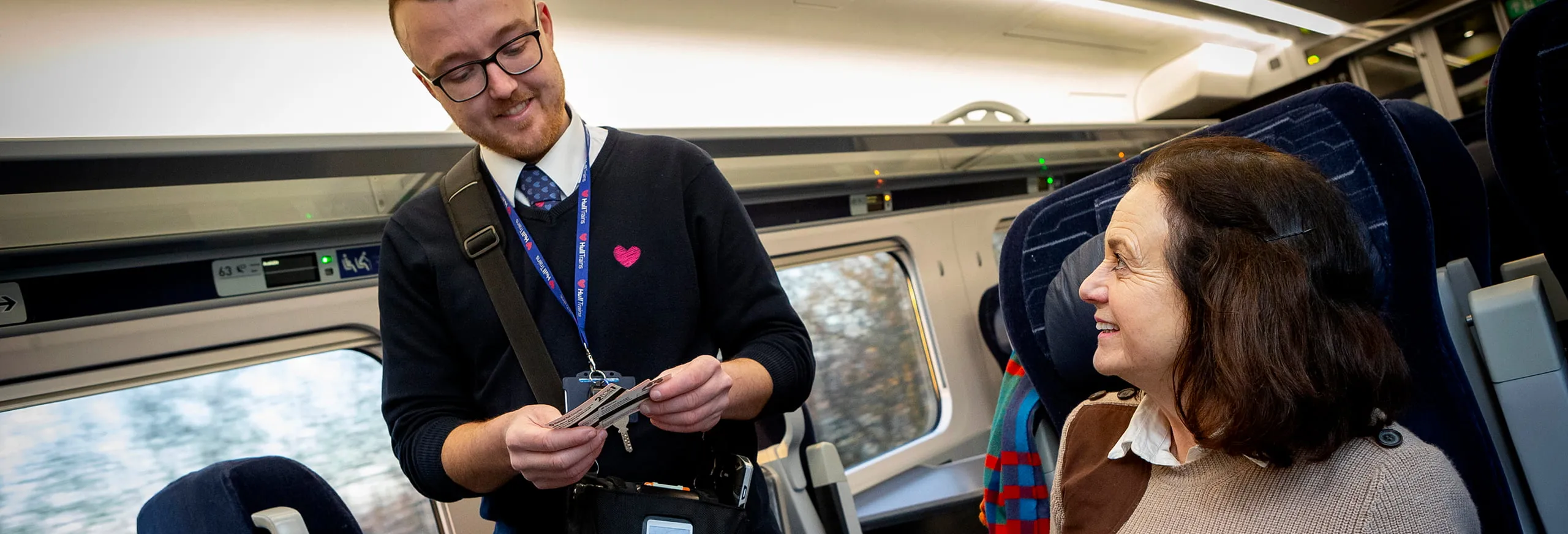 A Hull Trains Onboard Manager checking a customers ticket for travel