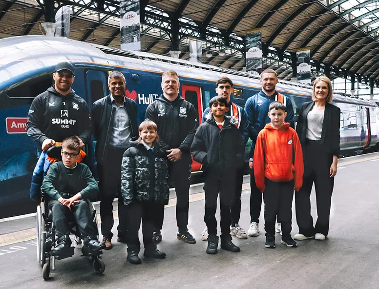Hull FC and Hull KR players with children from Hull Childrens University on the platform
