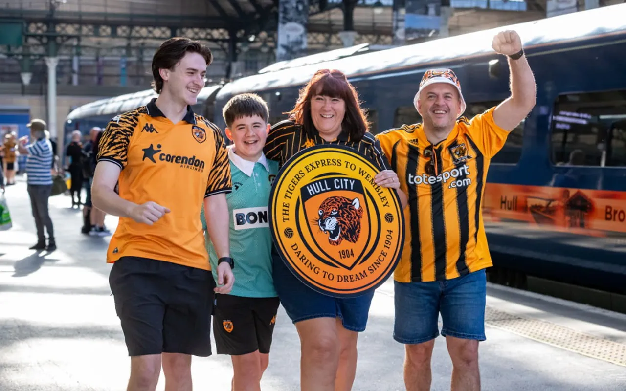 A group of Hull City supporters walking on the platform at Hull station